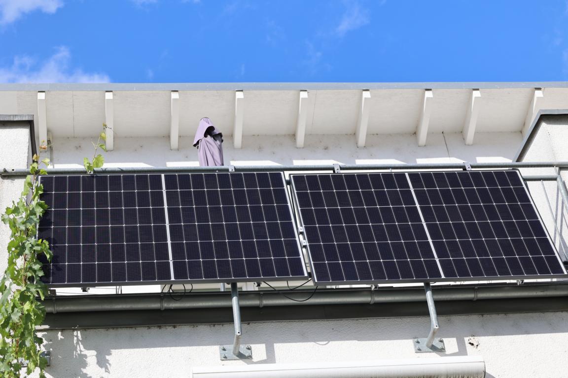 Das Solakon Balkonkraftwerk ist am Balkongeländer festgemacht und wird von vorne gezeigt, zu sehen sind die beiden Solarmodule in einem bestimmten Neigungswinkel im Test.